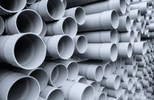Stacked plastic pipes, used as sewer pipes, are shown in bulk